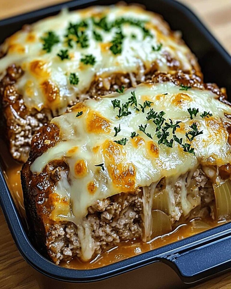 Cheesy French Onion Meatloaf sliced and served in a black roasting pan