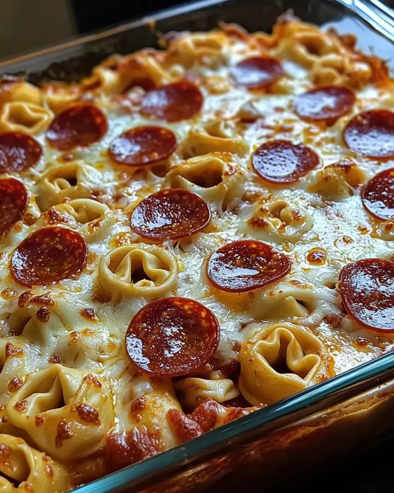 Cheese tortellini pepperoni pizza casserole baked with melted mozzarella and crispy pepperoni in a glass dish